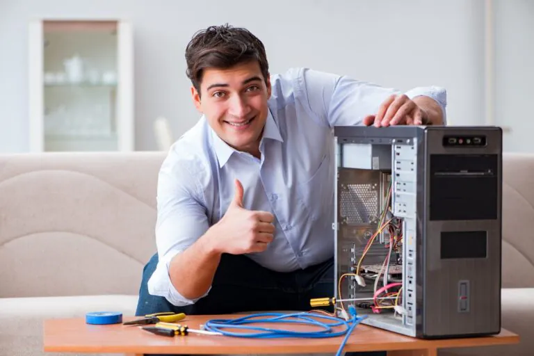 homem caucasiano sorridente mexendo em CPU ilustra artigo sobre salário de um técnico em TI