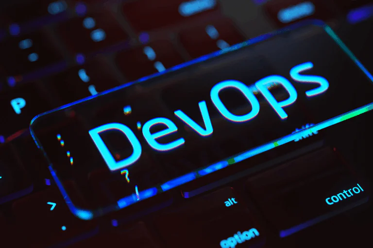 tecla iluminada com a palavra 'DevOps' em destaque, representando a integração entre desenvolvimento de software e operações de TI, em artigo sobre implementar DevOps.