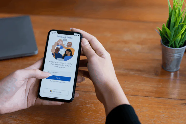 mãos femininas seguram celular aberto em app da Microsoft para ilustrar artigo sobre integração do Microsoft Teams com ferramentas de produtividade
