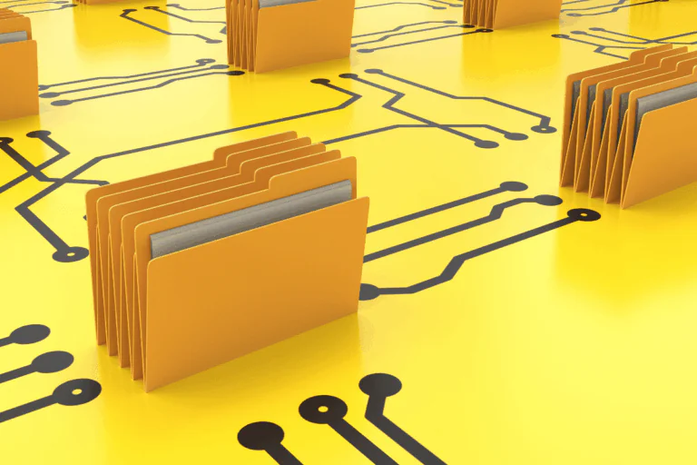 ilustrando artigo sobre migração para a nuvem, vemos na foto uma série de pastas pardas em cima de uma mesa amarela, onde adesivos pretos fazem as vezes de ligações de programação, integrando diversas pastas em si mesmas.