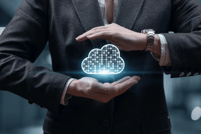 Na foto que ilustra artigo sobre benefícios do Oracle Database vemos o torso de um homem de terno, com um relógio na mão esquerda. Ele faz uma espécie de cumbuca com as mãos no ar e, no espaço vago entre elas, vemos a ilustração em neon de uma nuvem de pixels, representando um banco de dados na nuvem.