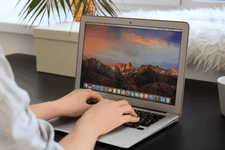 ilustrando artigo sobre versão do MacOS, vemos na foto uma mulher branca digitando em um MacBook Air da Apple