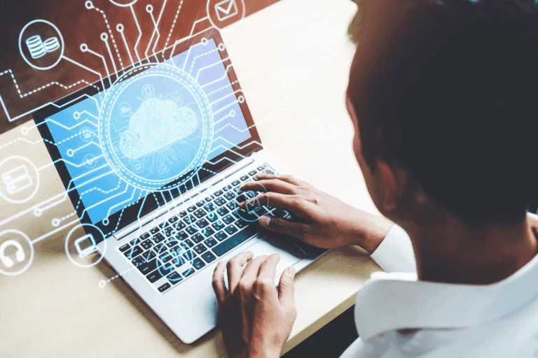 ilustra artigo sobre reduzir custos na nuvem foto conceitual de homem de costas, trabalhando em um notebook, com ícones e símbolos que remetam à computação em nuvem se projetando para fora da tela, em neon azul