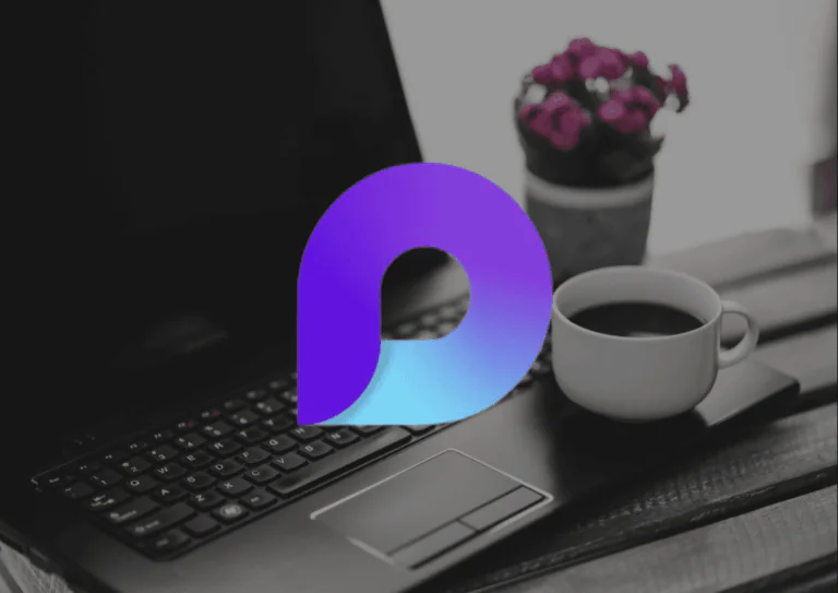 Ao fundo, uma fotografia com um notebook preto em destaque, com um pequeno vaso com flores rosas ao lado e uma xícara de café sobre a beirada abaixo do teclado do notebook; por cima da imagem, a logo do Microsoft Loop.