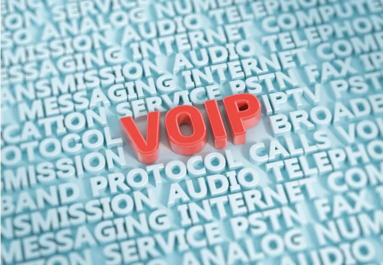 Representando o que é um telefone VoIP e como ele funciona, a imagem mostra, sobre fundo azul claro, várias palavras escritas no mesmo tom, mas em letras 3D, distribuídas em linhas contínuas preenchendo toda a imagem, com uma delas maior, centralizada, em destaque e na cor vermelha, escrito VOIP.