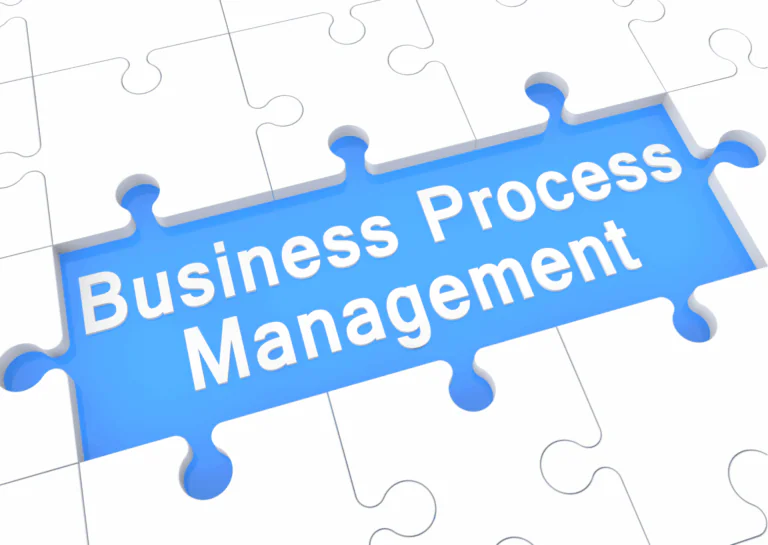 Peças de quebra-cabeça na cora branca com bordas sombreadas em cinza, estão encaixadas umas às outras; no centro, faltam três peças, deixando o fundo em azul aparecendo, e nele está escrito, em branco, Business Process Management; explicando o que é Business Process Management.