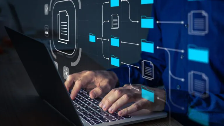 homem caucasiano digita no computador enquanto várias ilustrações de pastas de arquivo surgem defronte, mostrando a estrutura de um file system